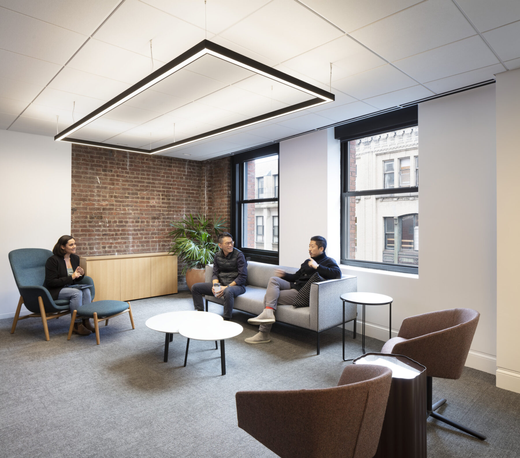 group of people seated in living room style meeting room conversing