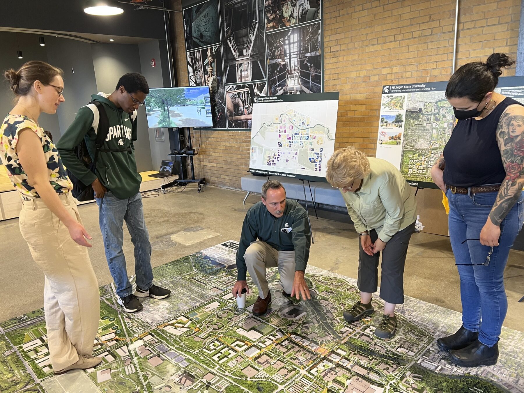 photograph of engagement session with participants interacting with framework maps and diagrams