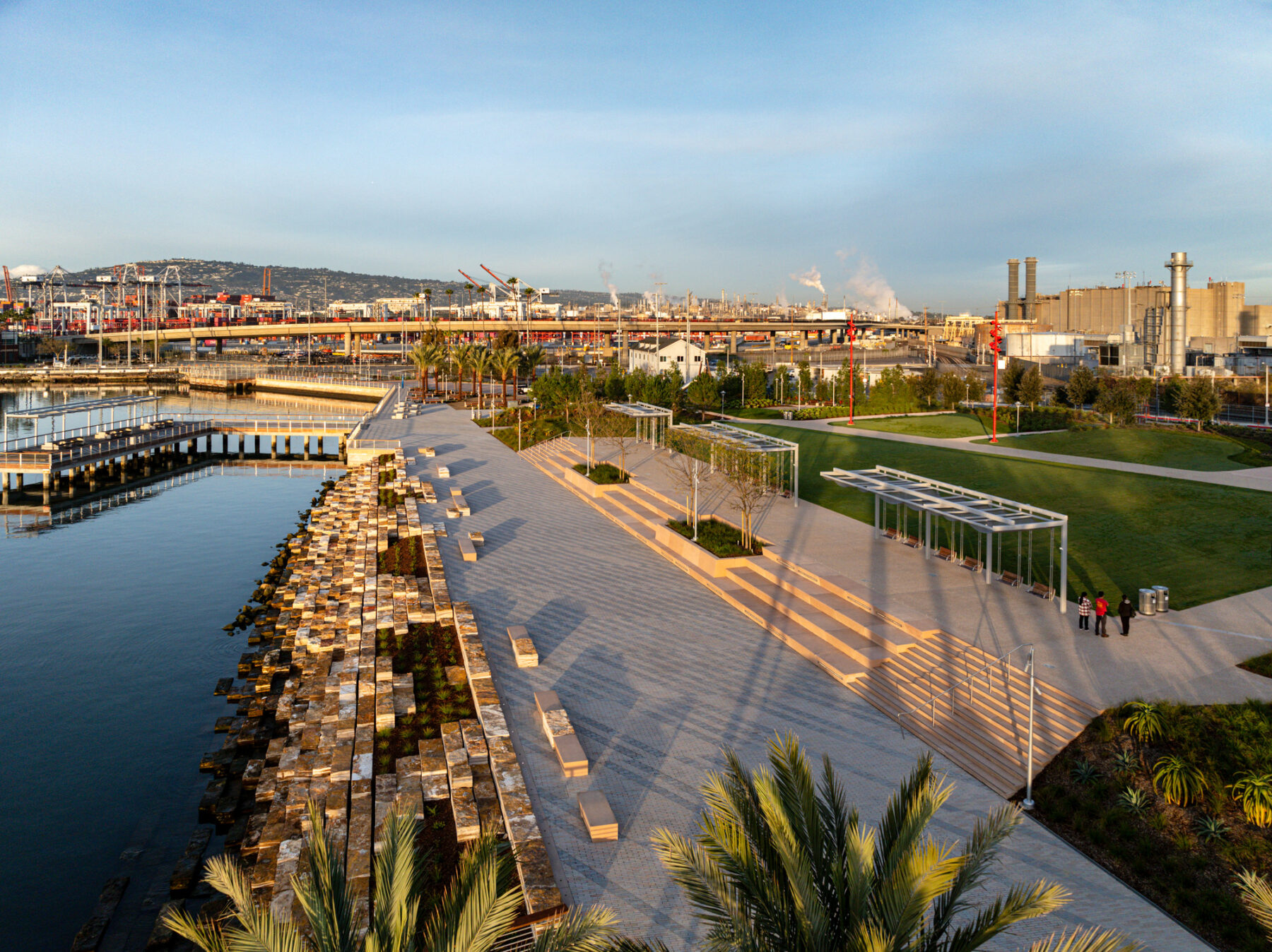 Aerial view of the rocks, stairs and pavilions with swings facing the water at sunset