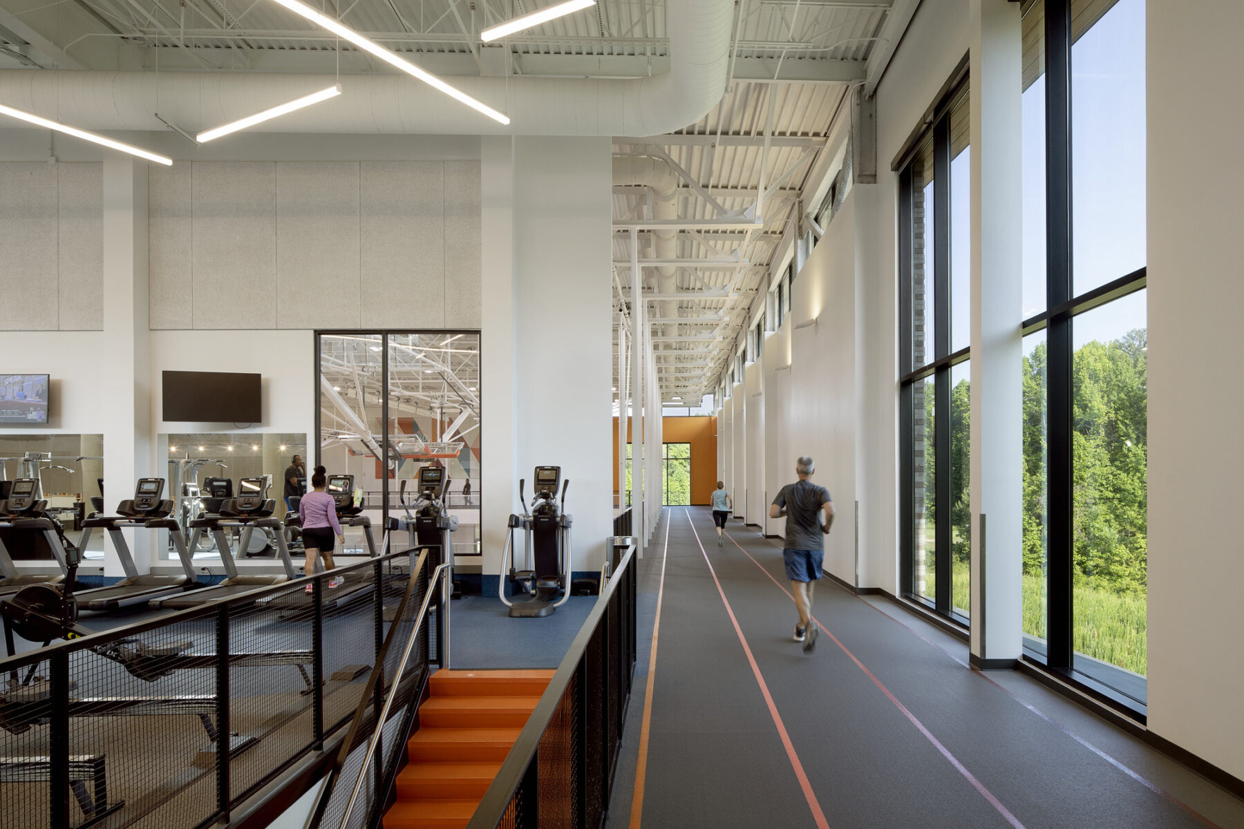 View of indoor track from the top of the stairs with runner moving through the space