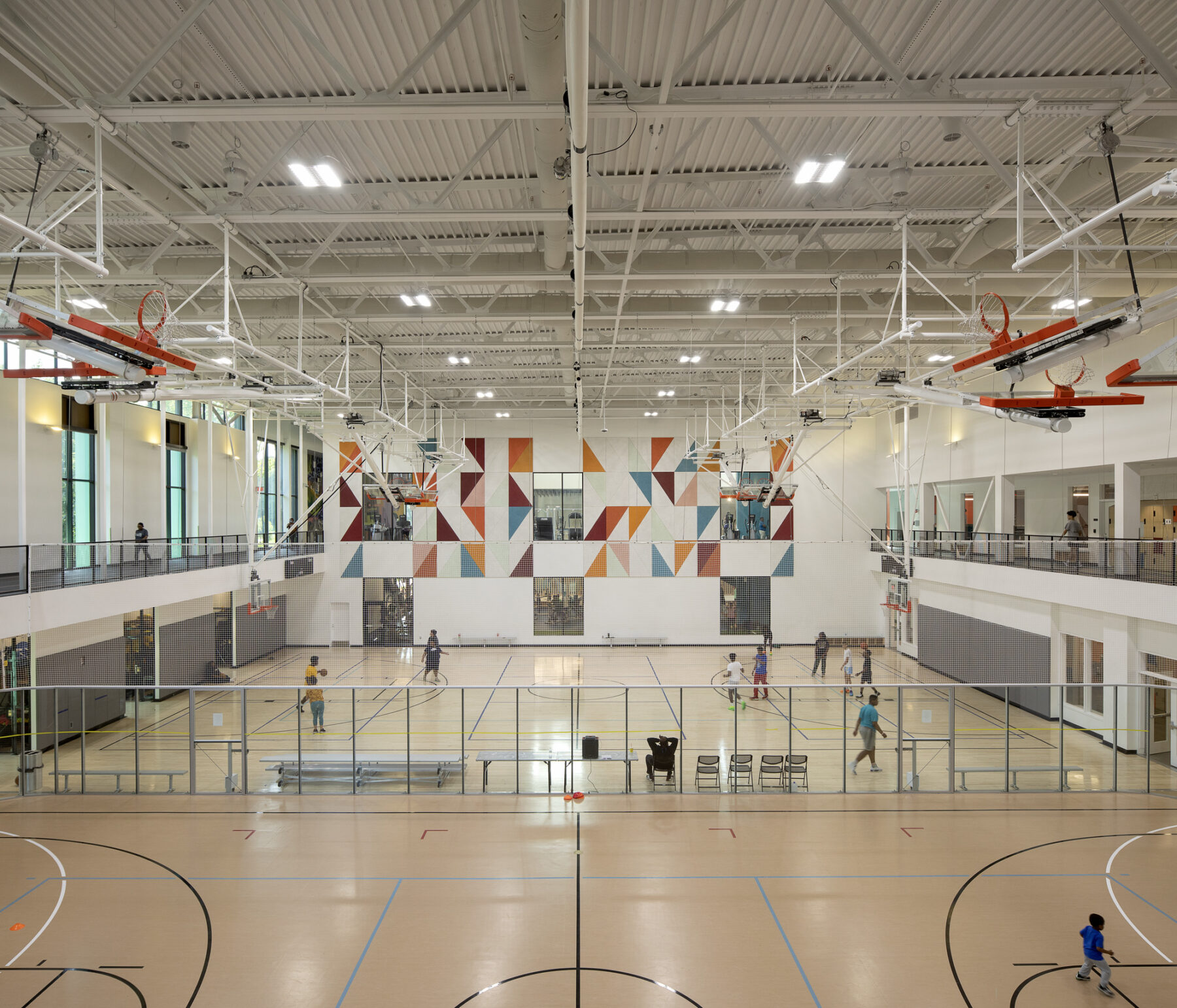 View into gymnasium courts from above, looking directly at the patterned wall