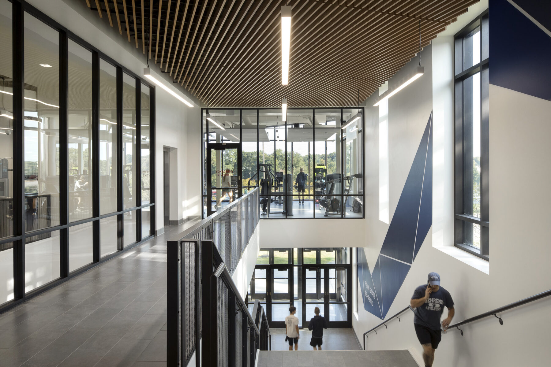 interior photograph of stair leading to northeast entry of recreation center. window to weight room space beyond