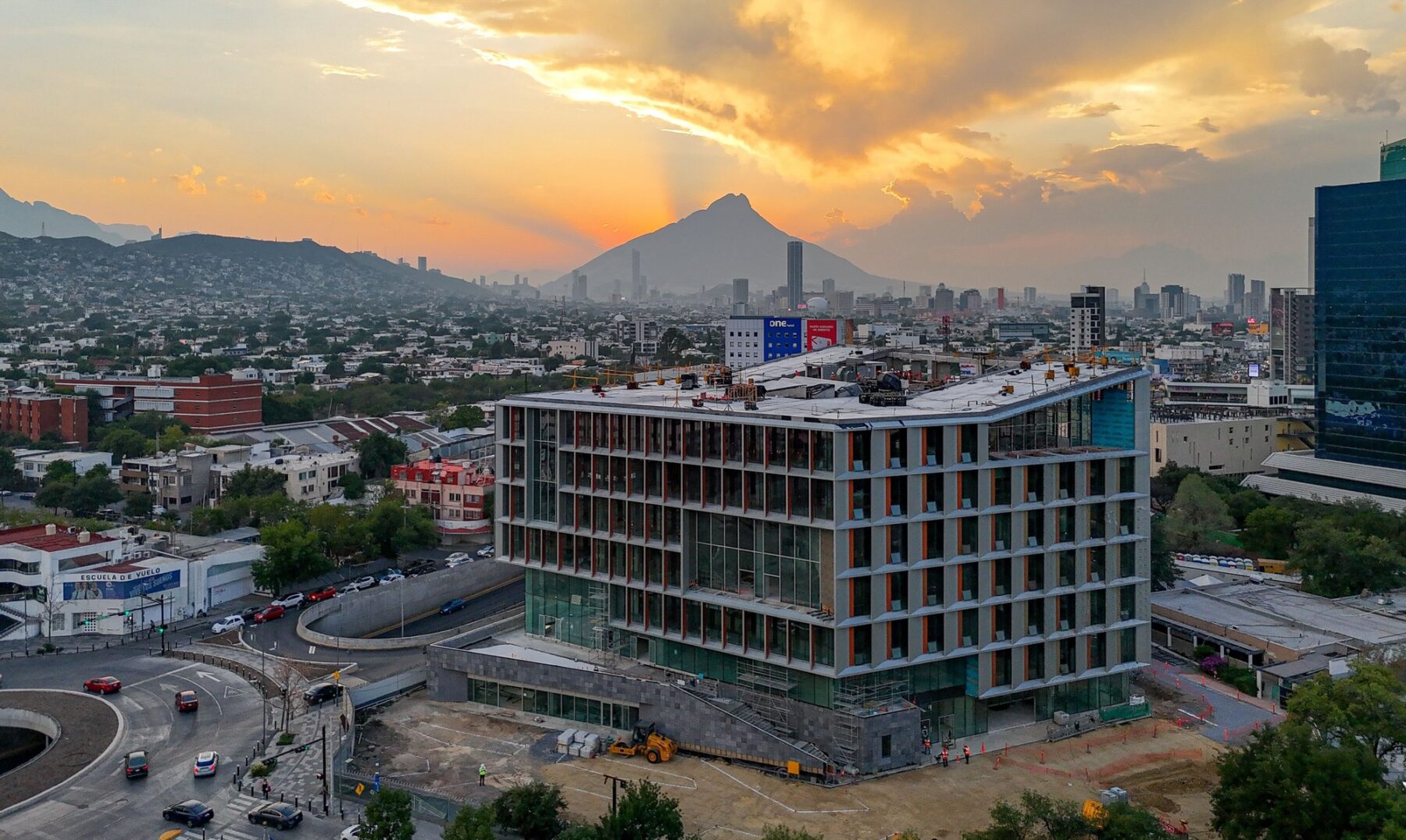 aerial photograph of building under construction with mountain range in background