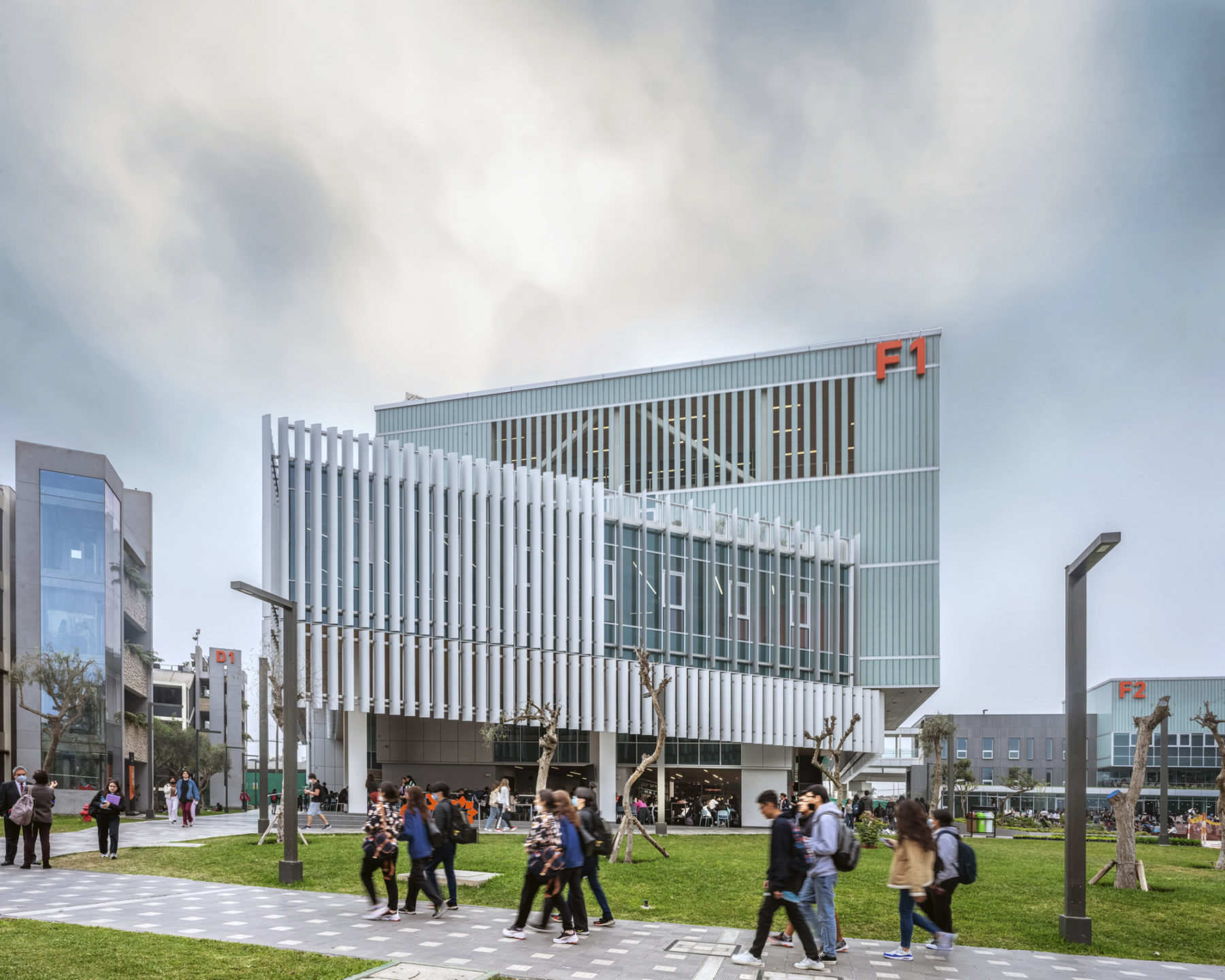 exterior elevational photo of building. students walk in groups on path in front of building.